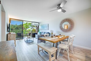 Une pièce spacieuse comprenant une table à manger, des chaises, un canapé et un ventilateur de plafond.