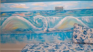 Une chambre à coucher ornée d’une fresque représentant des vagues océaniques et dotée d’un lit recouvert d’une couvre-lit sur le thème de la marine.