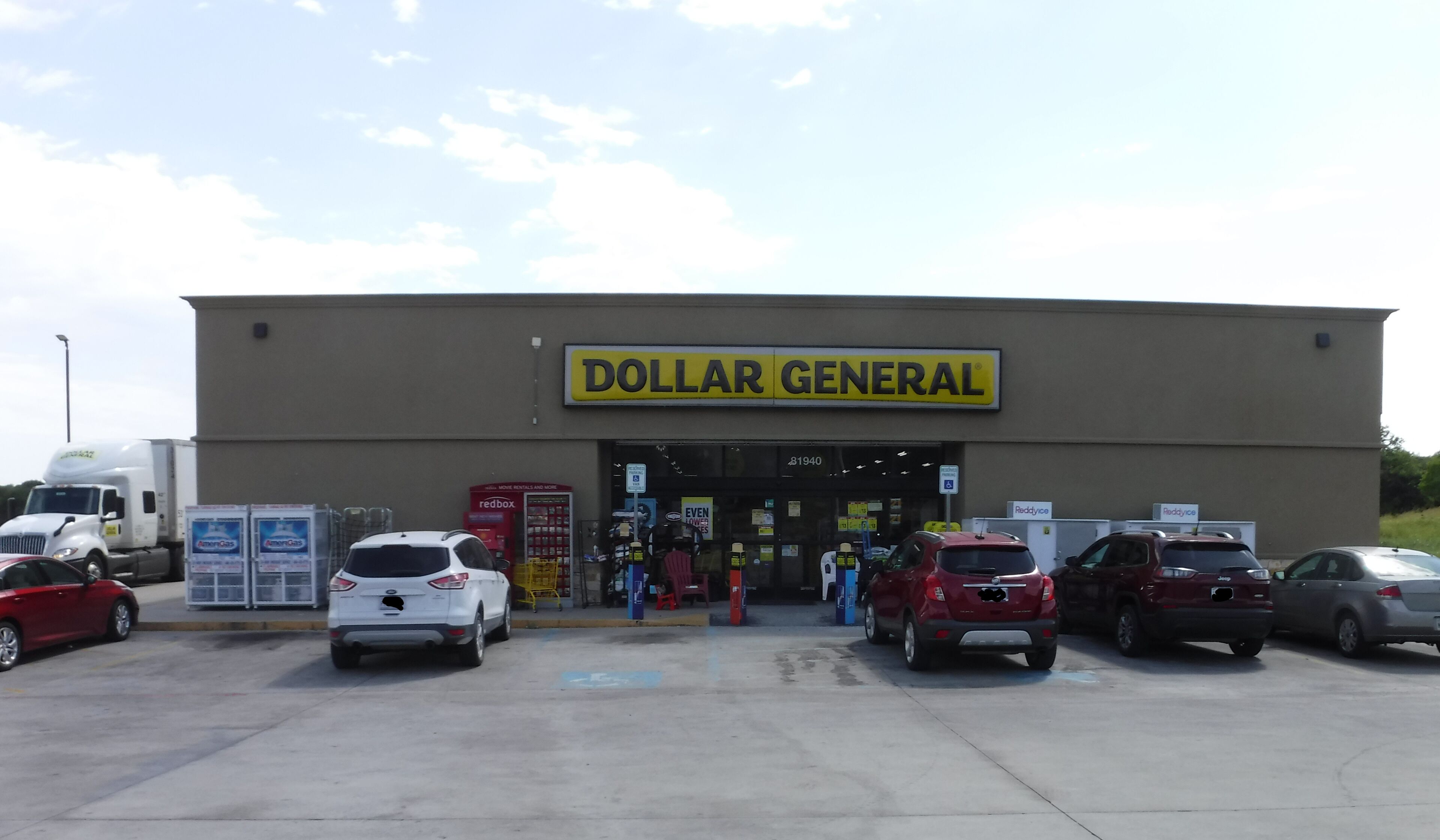 A Dollar General store with a parking lot and several cars parked in front.