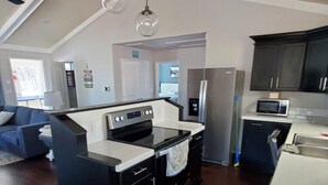 A modern kitchen with a central island, a microwave, and a refrigerator.