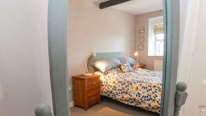 A bedroom with a bed, nightstand, and dresser. - Piccadilly View (Keighley)