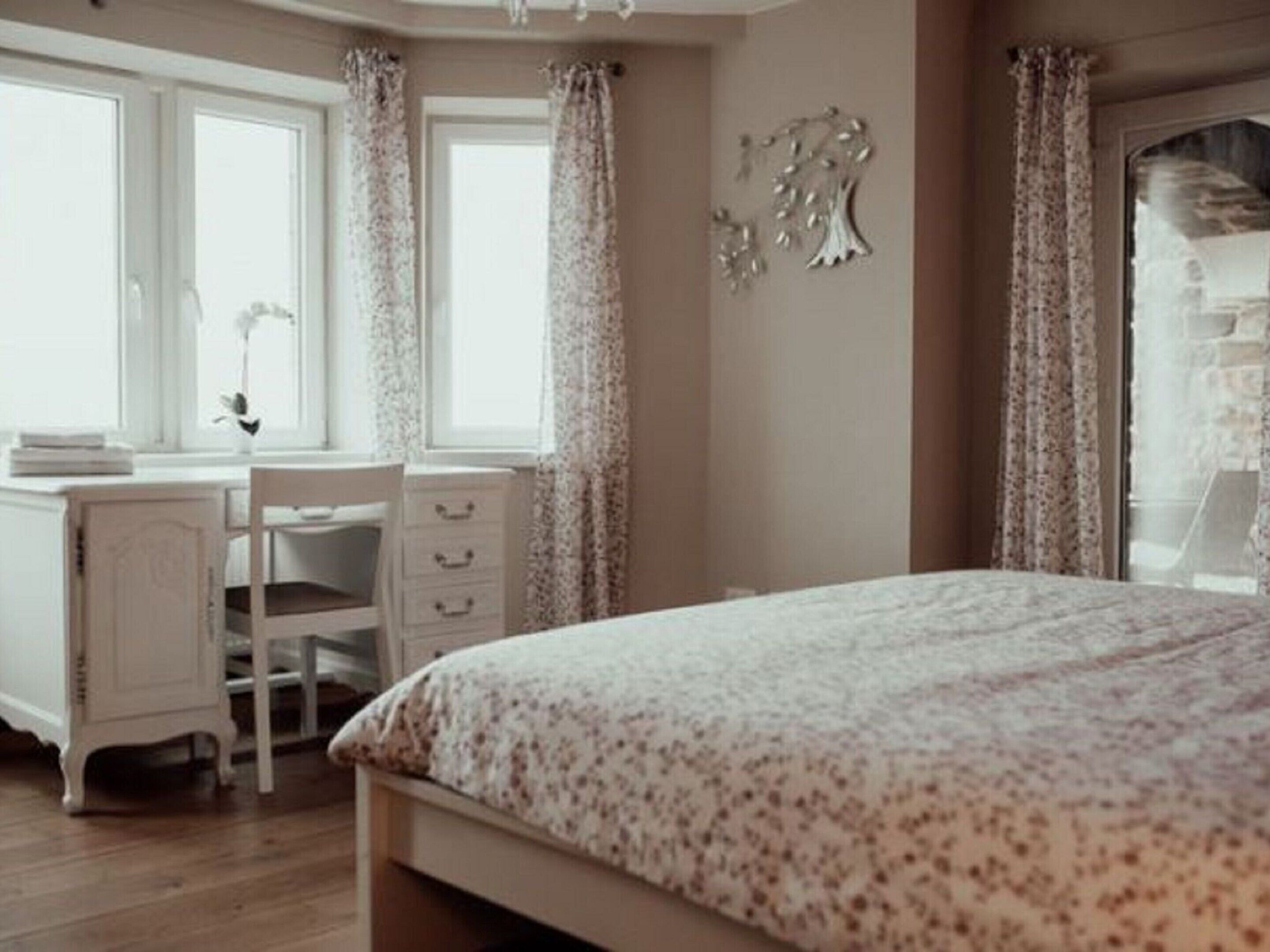 Un dormitorio con una cama, un escritorio y una silla.