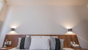 Ein Schlafzimmer mit einem hölzernen Kopfteil, zwei Nachttischlampen und einem Bett mit vielen Kissen.