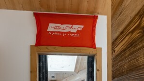 Puinen sisustus, jossa on punainen banneri, portaikko ja hylly, jossa on esineitä.