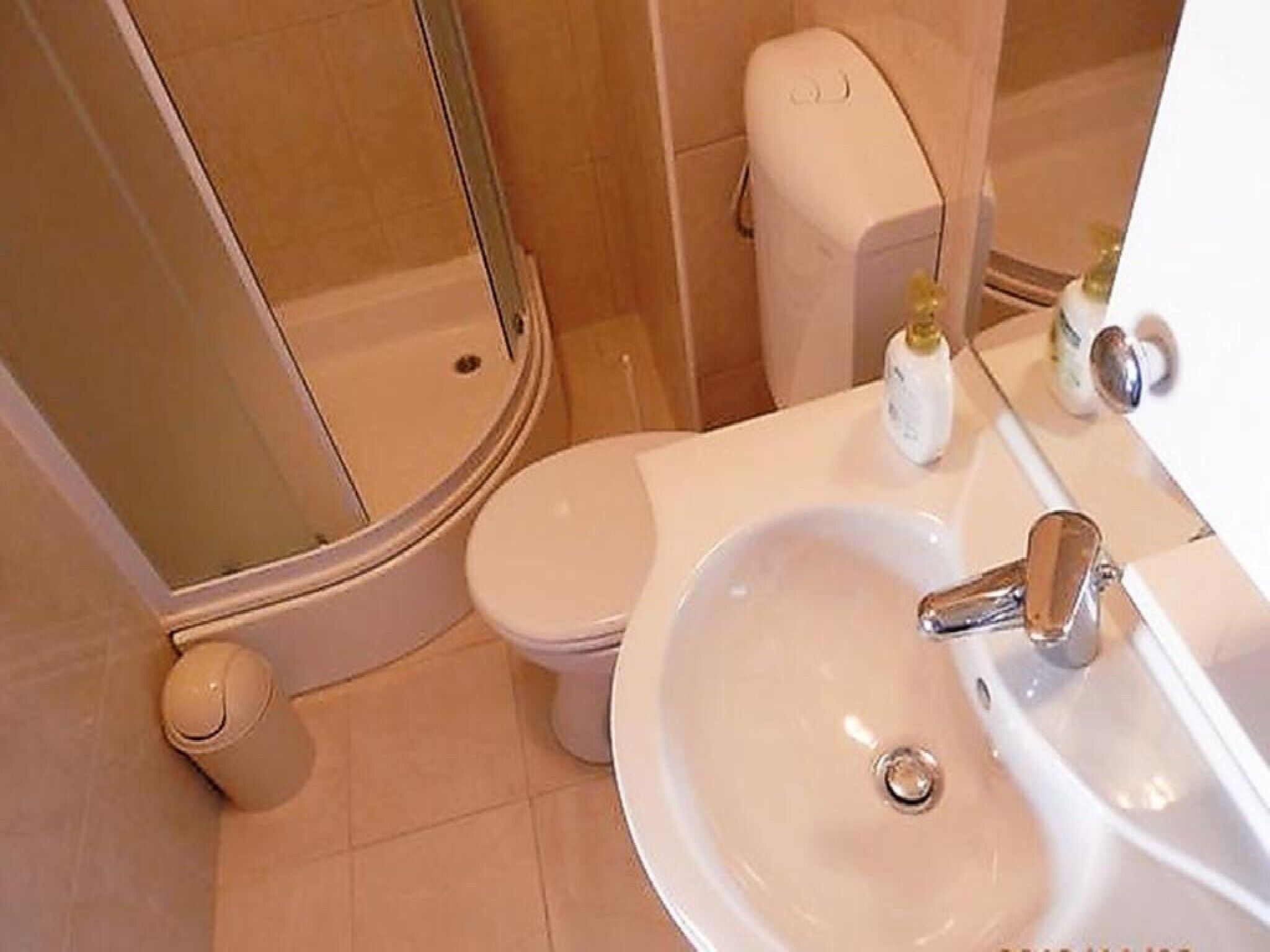 A bathroom with a toilet, sink, and shower.