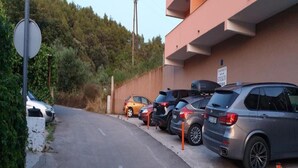 A parking lot with several cars parked in front of a building with a sign that reads "STAFF ONLY".