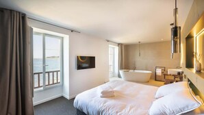 A modern hotel room with a large bed, a bathtub, and a view of the sea. - Cezon Island - Luxury duplex with magnificent sea (Landéda)