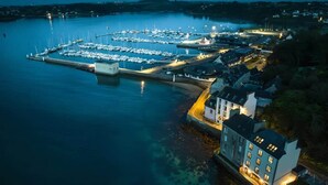 An aerial view of a marina with boats docked, a large building with multiple windows, and a smaller structure nearby. - Cezon Island - Luxury duplex with magnificent sea (Landéda)