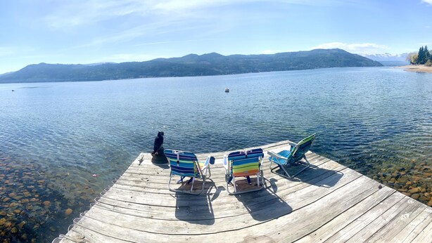 A wooden dock with clear water leading to a lake, surrounded by mountains. - Sunnyside Lakehouse - Semi-waterfront Shuswap Accommodation (Celista)