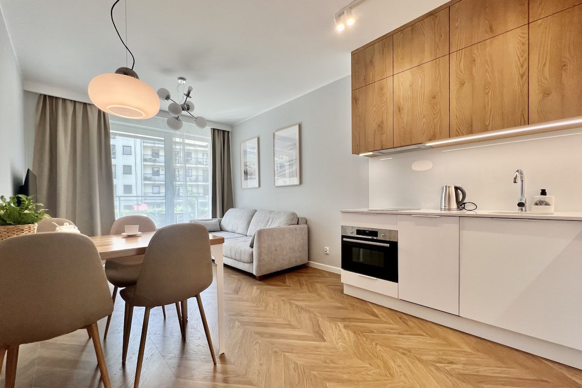 A modern kitchen with wooden cabinets, a built-in oven, and a sink.