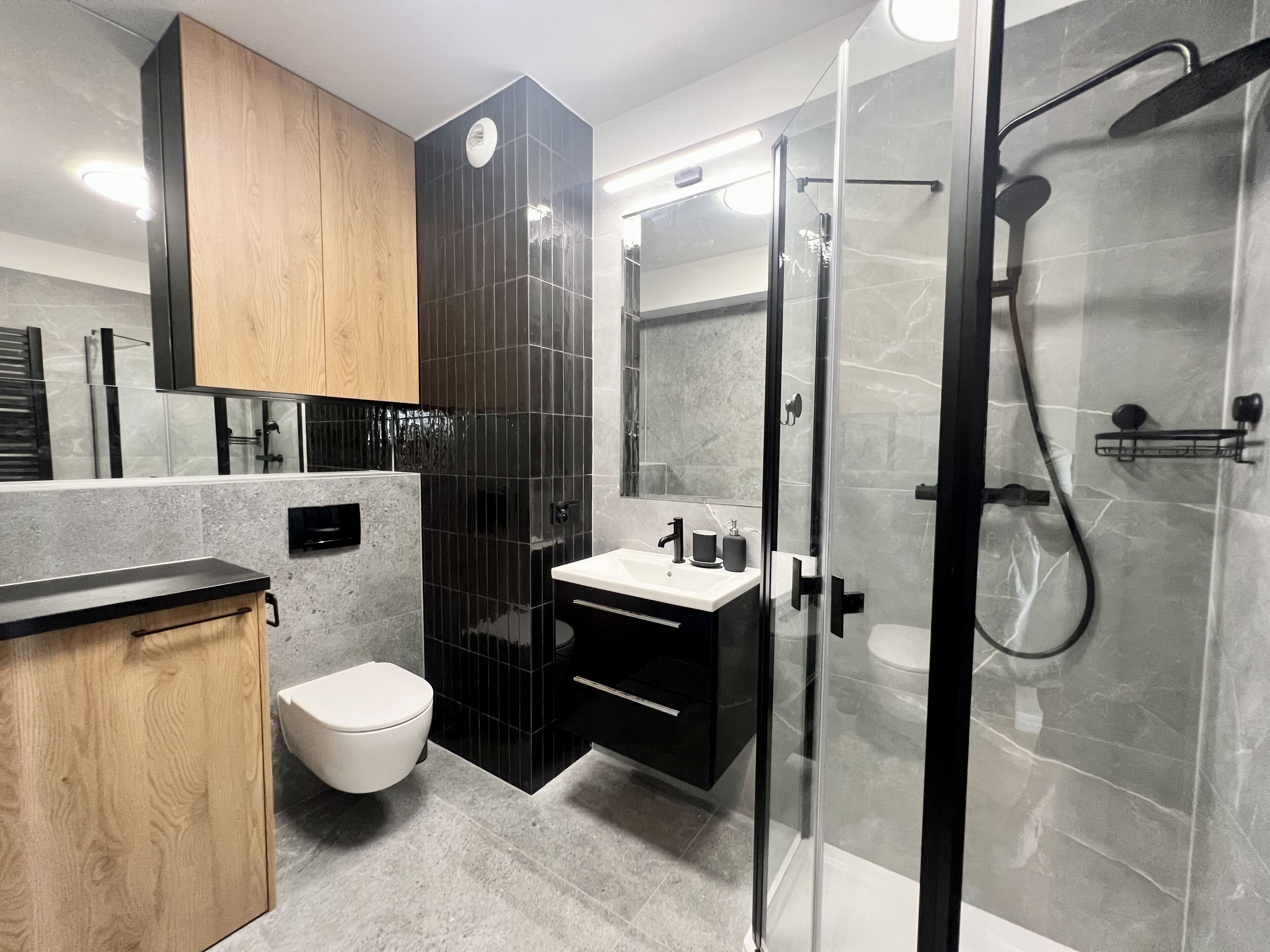 Un bagno moderno con toilette, lavandino e zona doccia.