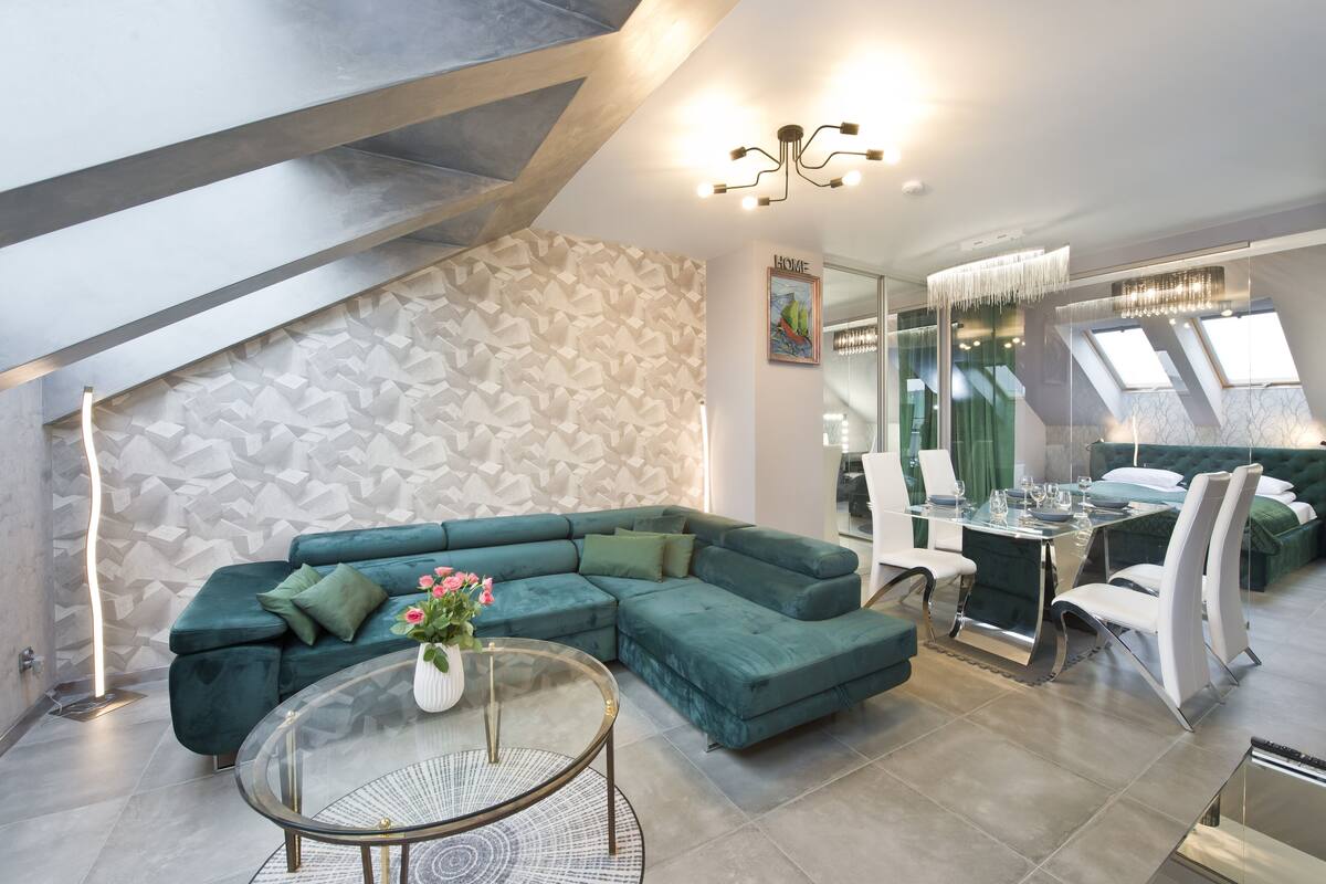 A modern living room with a sectional sofa, a glass coffee table, and a dining area with a table and chairs.
