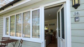 A house with a sliding glass door leading to a dining area with a table and chairs. - 14 The Dell (Norwich)