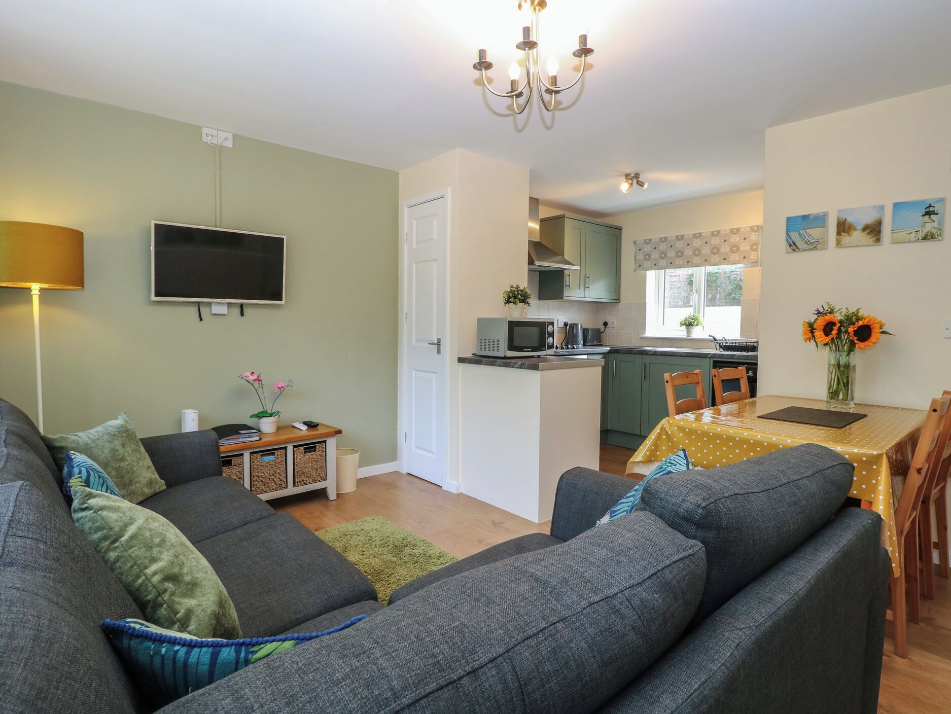 A modern living room with a sofa, a TV, and a dining area with a table and chairs.
