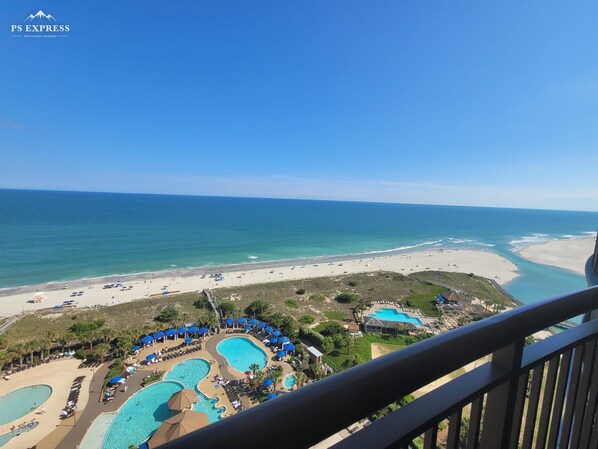 Een resort met meerdere zwembaden, een strand en uitzicht op de oceaan.