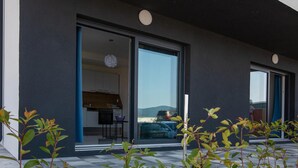 A modern building with large sliding glass doors leading to a kitchen and dining area.