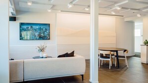 Een moderne lobby met een bank, een tafel en een stadsgezicht schilderij.