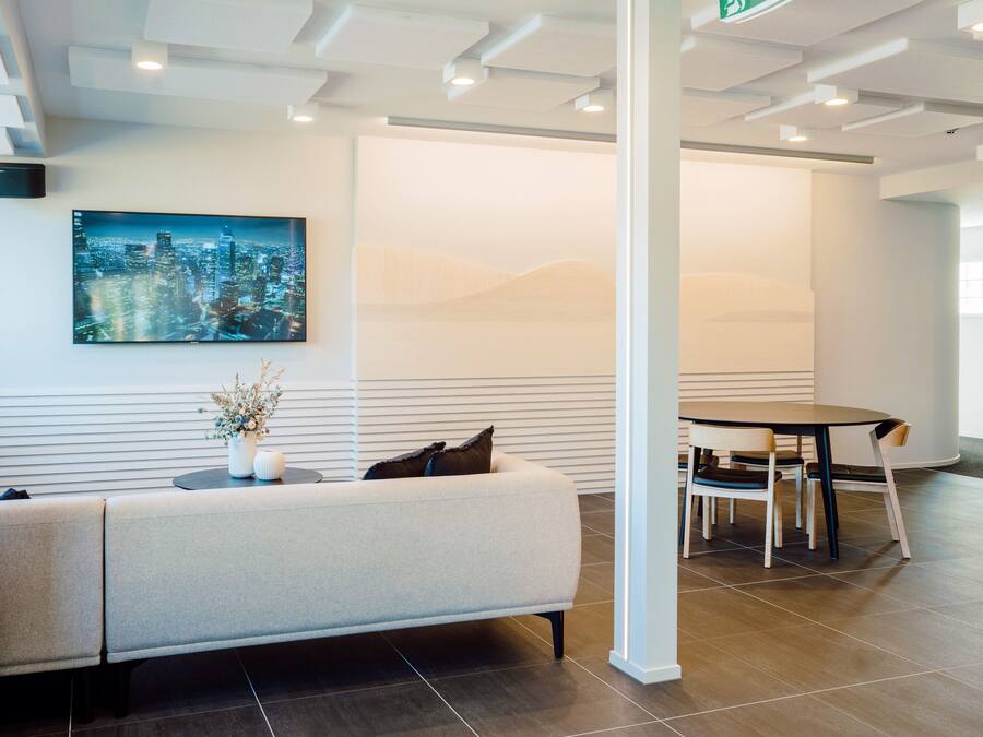 A modern lobby with a sofa, a table, and a cityscape painting.