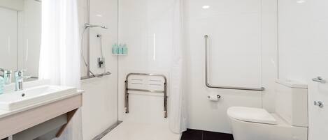 A modern bathroom with a white sink, a toilet, and a shower area.