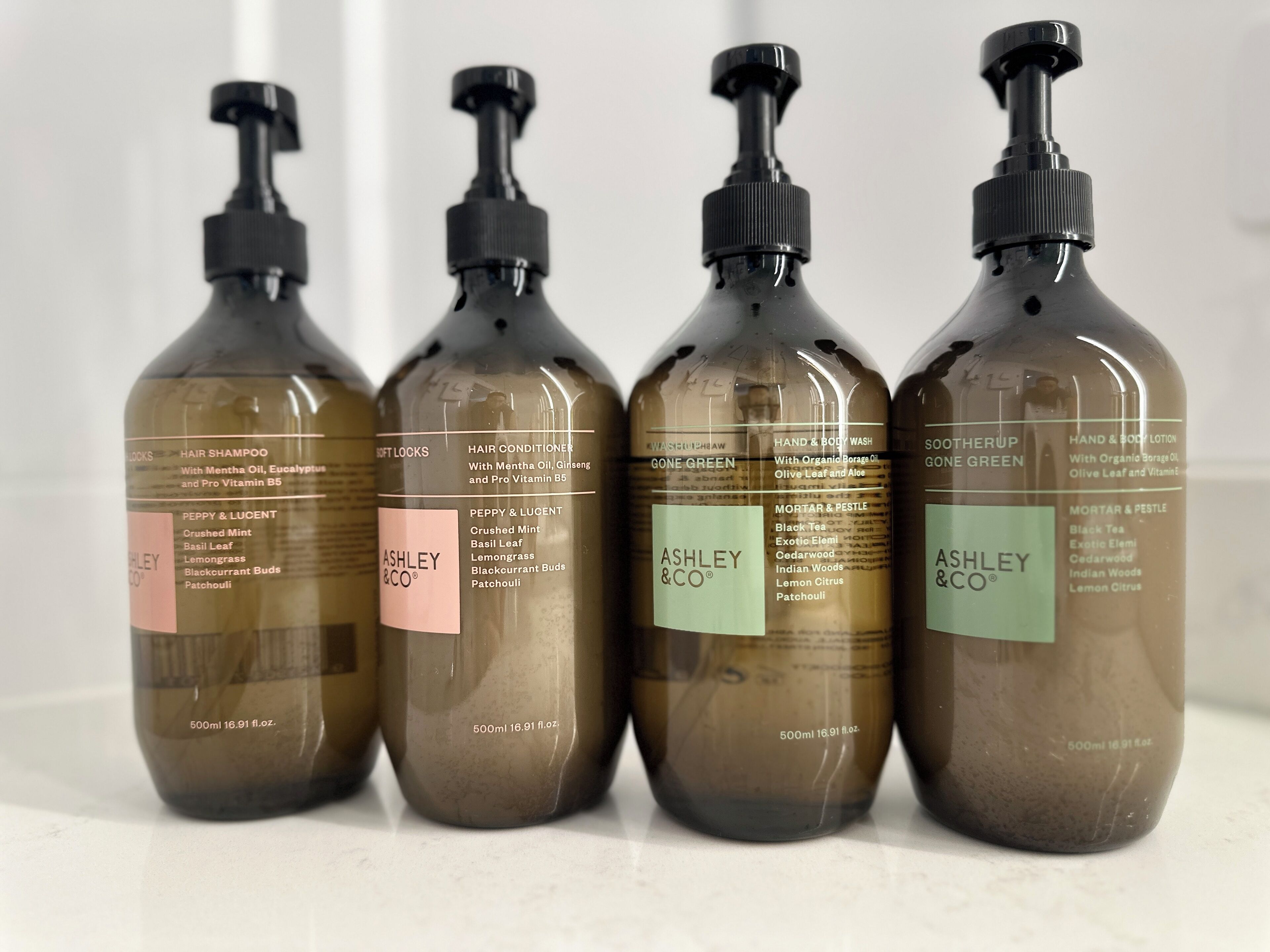 Four bottles of Ashley & Co. hair care products.