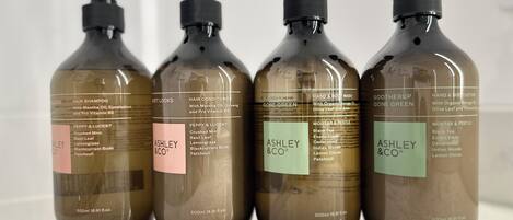 Four bottles of Ashley & Co. hair care products.