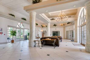 A spacious lobby with high ceilings, large windows, and a central seating area.