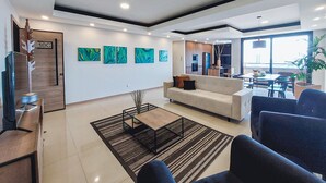 A modern living room with a sofa, coffee table, and artwork on the wall. - Luxurious and cozy brand new apartment! (Santa Cruz de la Sierra)