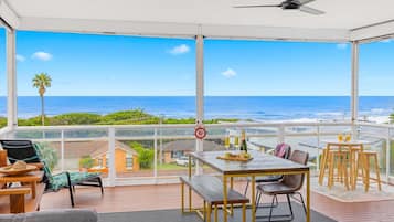 Enjoy a serene ocean view from this spacious balcony with comfortable seating and a dining area.