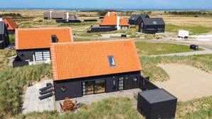 Ein modernes Haus mit Ziegeldach, eingebettet in eine natürliche Landschaft.