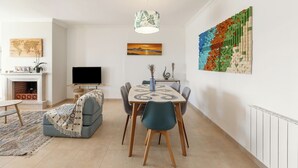Una sala de estar moderna con comedor, chimenea y una gran obra de arte abstracta en la pared.