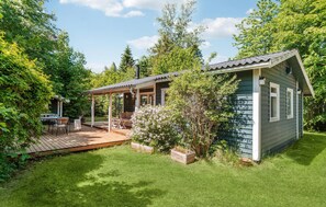 Eine kleine Holzhütte mit einer Holzterrasse und einer überdachten Veranda.