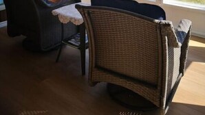 A room with two wicker chairs, a small table, and large windows overlooking a body of water. - 全景湖景私密临水度假屋 (Kawartha Lakes)