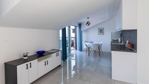 Una cocina moderna con comedor, que incluye un ventanal grande, una mesa con sillas y una encimera de cocina.