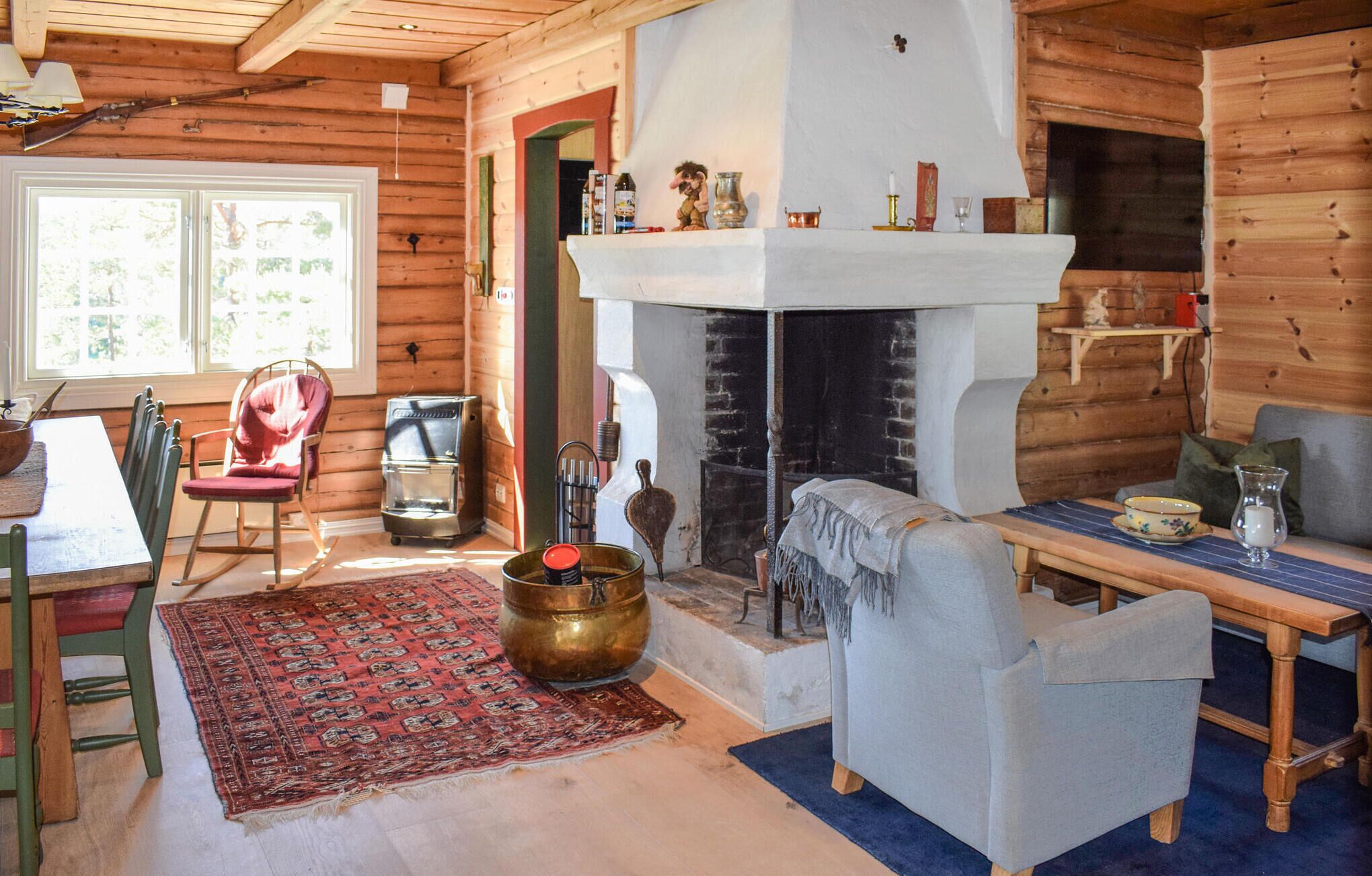 L’intérieur d’un chalet confortable, avec une cheminée, des meubles en bois et un coin repas.