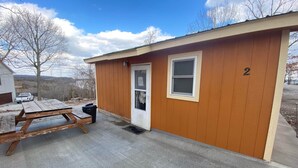 A small, single-story building with a wooden exterior and a number '2' on the side. - Cabin 2 - Reel and Trigger (Tom Township)