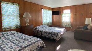 A room with two beds, a TV, and a sofa. - Cabin 2 - Reel and Trigger (Tom Township)
