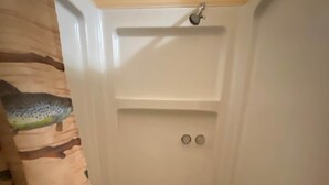 A bathroom with a shower, a toilet, and a sink. - Cabin 6 - Reel and Trigger (Tom Township)