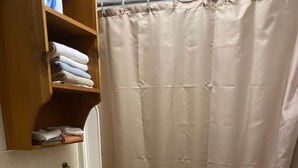 A bathroom with a toilet, sink, and a shower curtain. - Eagle's Nest - Reel and Trigger (Tom Township)