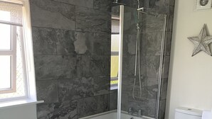 A modern bathroom with a freestanding bathtub, a glass-enclosed shower, and a toilet. - Hurricane - 2 bed apartment (Friskney)