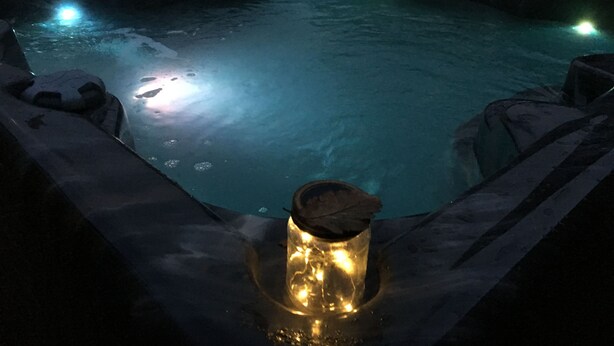 A hot tub with a candle in the center, surrounded by rocks. - Hurricane - 2 bed apartment (Friskney)
