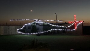 A helicopter with lights on its body parked on a concrete surface. - Glamping pod helicopter (Friskney)