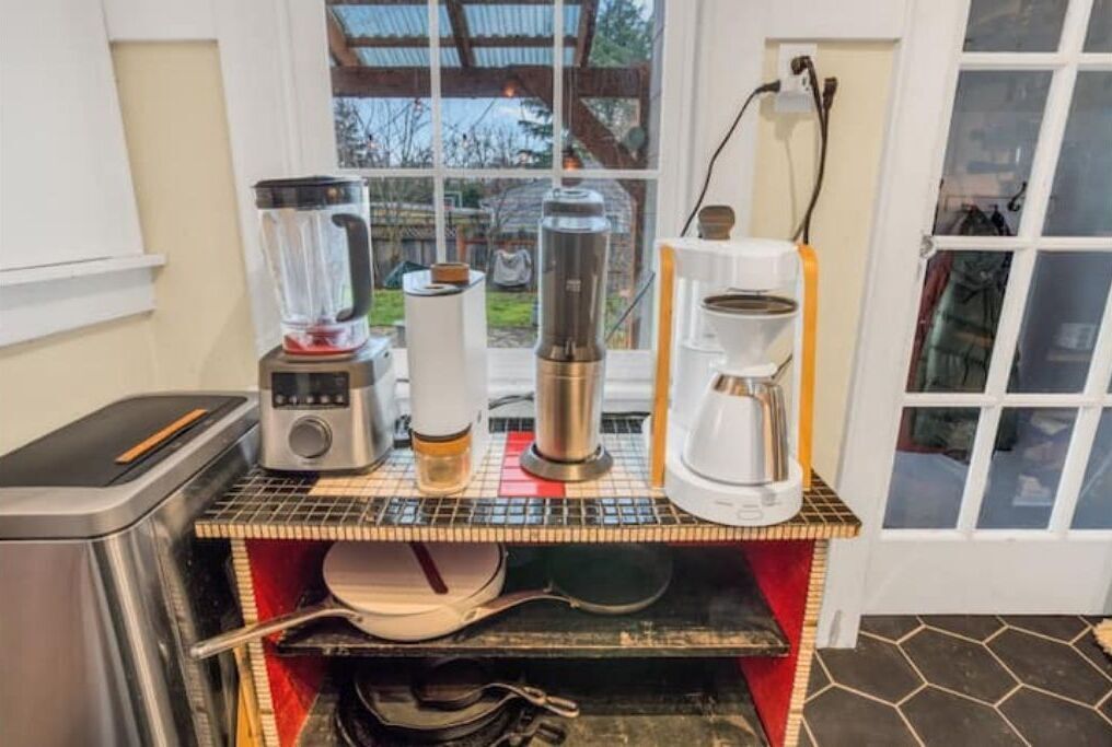 A kitchen counter with various appliances including a blender, coffee maker, and toaster.