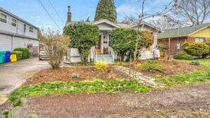A two-story house with a front yard, a chimney, and a garage. - 2Bd Bungalow with backyard sauna, by Alberta Arts (Portland)