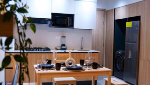 Een moderne keuken met houten kastjes, een centraal eiland en een zithoek met een bank.