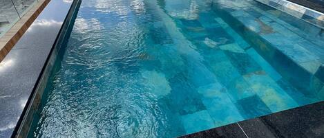 Una piscina al aire libre, una piscina climatizada