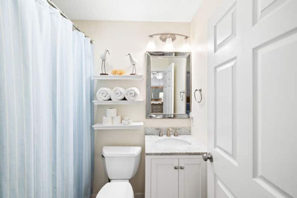 A bathroom with a toilet, sink, and shower curtain.
