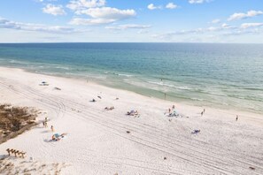 A wide beach with clear skies and calm waters.