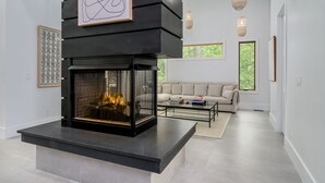 Uma sala de estar moderna com lareira, um sofá e uma mesa de centro.
