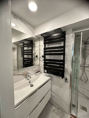 Een douche, een haardroger, handdoeken, toiletpapier