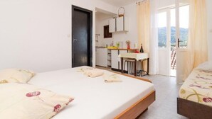Ein Schlafzimmer mit Bett, Schreibtisch und Blick ins Freie.